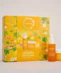 Luméne Paris 'Garden of Glow' skincare set featuring a bright yellow floral gift box with three products: a serum dropper bottle, a glow boostessence jar, and a glow moisturizer jar, displayed on a light gray background.